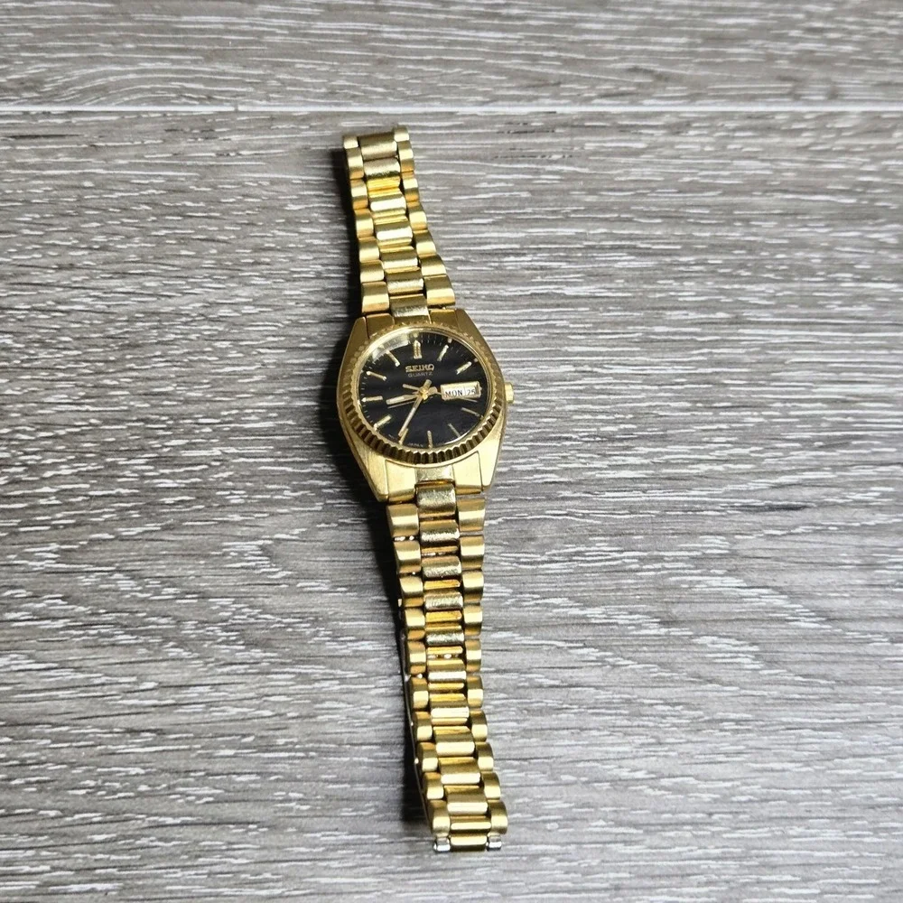 Seiko Quartz Women's Gold Tone Watch Black Dial Day Date Fluted Bezel 7N83-006M